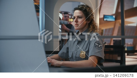 Airport Safety Personnel Analyzing Xray Images at Departure Checkpoint Airport Safety Personnel Analyzing Xray Images at Departure Checkpoint 141209178