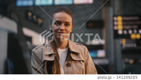 Beautiful Woman Smiling in Crowded Airport Terminal with Motion Blur Passengers 141209285