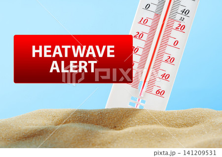 Heatwave alert showing thermometer reading high temperature over sand background 141209531