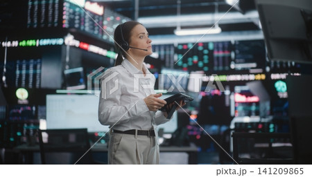 Focused Female Broker Manages Market Activity on Busy Trading Floor Focused Female Broker Manages Market Activity on Busy Trading Floor 141209865