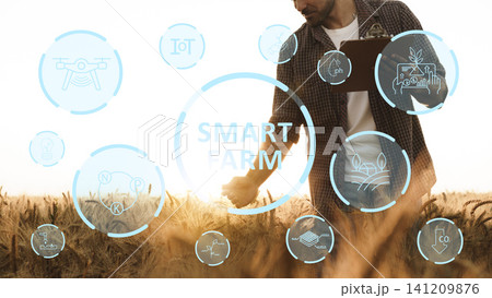Farmer using technology on smart farm to improve crop production and management Farmer using technology on smart farm to improve crop production and management 141209876