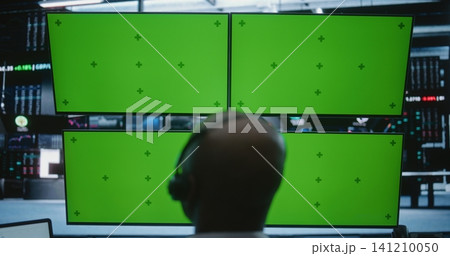 Male Trader Working Modern High Tech Desk With Four Green Screen Monitors in Busy Financial Office Male Trader Working Modern High Tech Desk With Four Green Screen Monitors in Busy Financial Office 141210050