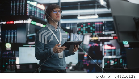 Man in Glasses Holds Digital Tablet, Looking Up Large Data Displays Man in Glasses Holds Digital Tablet, Looking Up Large Data Displays 141210128