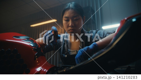 Female Mechanic Beside Partially Disassembled Motorcycle, Tired and Discouraged Female Mechanic Beside Partially Disassembled Motorcycle, Tired and Discouraged 141210283