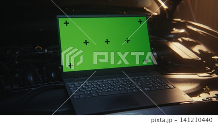 Laptop with Green Screen and Tracking Markers Positioned on Car Engine Laptop with Green Screen and Tracking Markers Positioned on Car Engine 141210440