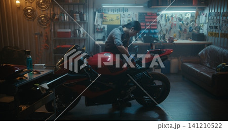 Female Picks Up Motorcycle Battery Positions it Into Compartment, and Reconnects Terminals Female Picks Up Motorcycle Battery Positions it Into Compartment, and Reconnects Terminals 141210522