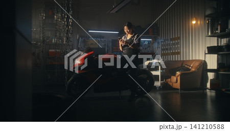 In Garage Setting, Woman Rider Briefly Stops Routine to Captures Sunset In Garage Setting, Woman Rider Briefly Stops Routine to Captures Sunset 141210588