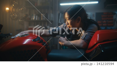 Technician in Overalls Polishing Sport bike With Microfiber Cloth Until Glitters Technician in Overalls Polishing Sport bike With Microfiber Cloth Until Glitters 141210594