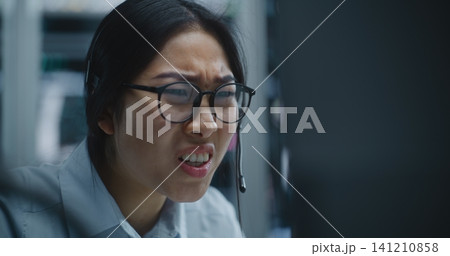 Female Trader Receives Call Via Headset While Monitoring Financial Data Female Trader Receives Call Via Headset While Monitoring Financial Data 141210858
