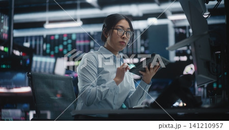 Female Expert Investor Monitoring Real Time Data and Communicating in Futuristic Hub. Female Expert Investor Monitoring Real Time Data and Communicating in Futuristic Hub. 141210957