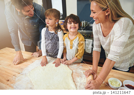 Learning, happy and family baking food in kitchen together, bonding and smile in home. Pizza, mother and father with kids cooking, teaching and help parents with flour dough for preparation at table Learning, happy and family baking food in kitchen together, bonding and smile in home. Pizza, mother and father with kids cooking, teaching and help parents with flour dough for preparation at table 141211647
