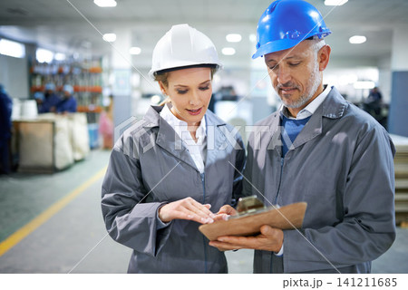 Man, woman and conversation with clipboard in factory for quality inspection or safety checks and process monitoring. Team, communication and board for manufacturing information in printing warehouse Man, woman and conversation with clipboard in factory for quality inspection or safety checks and process monitoring. Team, communication and board for manufacturing information in printing warehouse 141211685