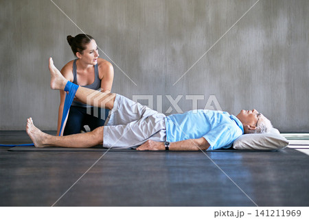 Therapist, legs and senior man with resistance band for physical therapy at rehabilitation center. Medical, help and physiotherapist with elderly male patient with consultation for injury at clinic. Therapist, legs and senior man with resistance band for physical therapy at rehabilitation center. Medical, help and physiotherapist with elderly male patient with consultation for injury at clinic. 141211969