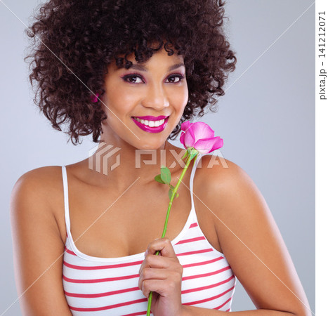 Portrait, beauty and black woman with flower in studio for skincare, floral cosmetics or dermatology on gray background. Lipstick, pink rose and female model for makeup, glowing skin and eyeshadow 141212071