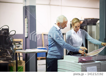 Machine, business people and check print quality in creative industry, warehouse and sector for design project. Teamwork, man and woman communication, discussion and work working in collaboration 141212192