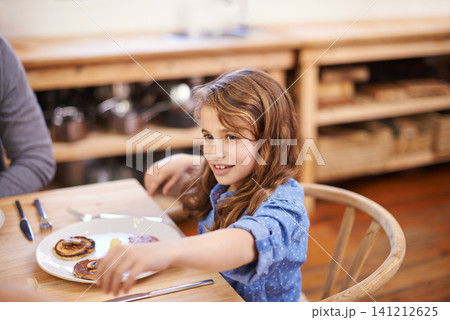 Girl child, breakfast and pancakes in house with table, smile and family for wellness, health and energy. Female kid, food and happy in home together with parent for nutrition, eating and strength. 141212625