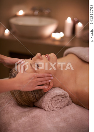 Face massage, spa and relax with woman, luxury and candle with hospitality and stress relief. Person, facial and girl with wellness or healthy with vacation or beauty with holiday, detox or self care 141212798