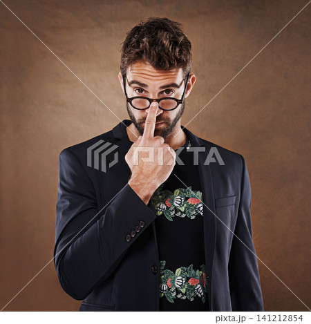 Glasses, fashion and portrait of man in studio with blazer for classy, stylish and trendy outfit with confidence. Spectacles, serious and male person with elegant and fancy style by brown background. Glasses, fashion and portrait of man in studio with blazer for classy, stylish and trendy outfit with confidence. Spectacles, serious and male person with elegant and fancy style by brown background. 141212854