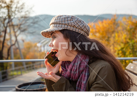 Woman happy gesturing while talking on phone in autumn Woman happy gesturing while talking on phone in autumn 141214219