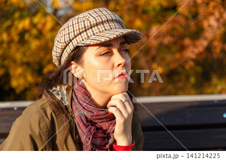 Annoyed young woman on park bench in autumn Annoyed young woman on park bench in autumn 141214225