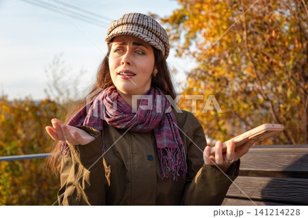 Woman arguing while holding a smartphone Woman arguing while holding a smartphone 141214228