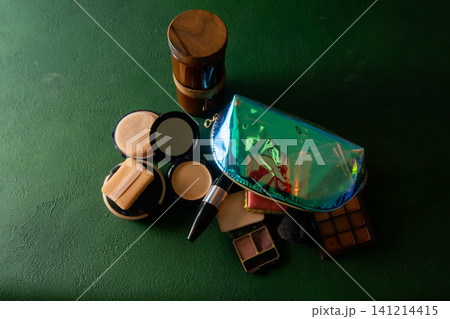 Makeup Collection with Iridescent Bag, Eyeshadow Palette, and Beauty Products Cosmetic on Green background Makeup Collection with Iridescent Bag, Eyeshadow Palette, and Beauty Products Cosmetic on Green background 141214415