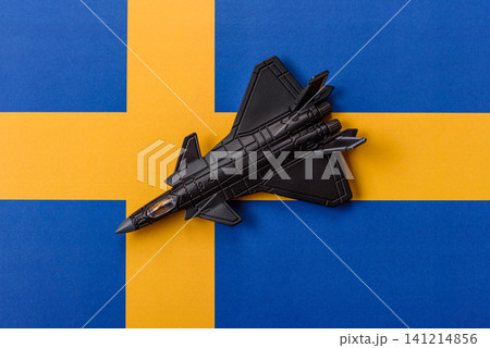 A fighter jet against the Swedish flag as a conceptual background representing defense A fighter jet against the Swedish flag as a conceptual background representing defense 141214856