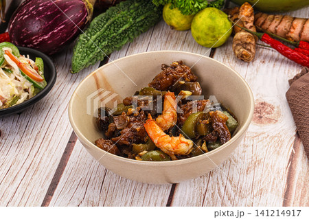 Bowl of stir fried shrimp and eggplant with fresh vegetables on wooden table Bowl of stir fried shrimp and eggplant with fresh vegetables on wooden table 141214917