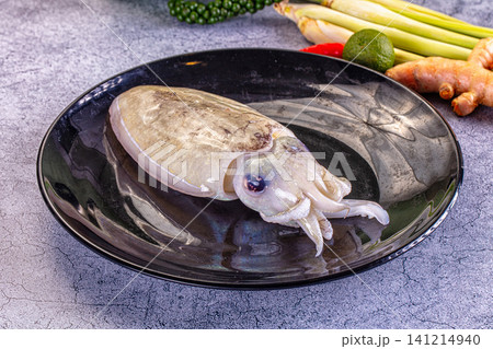 Fresh cuttlefish on dark ceramic plate with lemongrass lime and ginger Fresh cuttlefish on dark ceramic plate with lemongrass lime and ginger 141214940