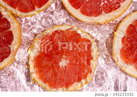 Grapefruit slices under rippling water, macro abstract background. Grapefruit slices under rippling water, macro abstract background. 141215332