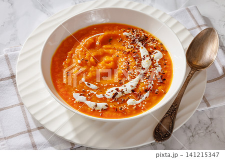 spiced sweet potato soup in a white bowl 141215347