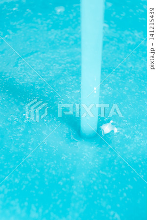 Thick blue soap pouring into a container, concept of laundry or manufacturing Thick blue soap pouring into a container, concept of laundry or manufacturing 141215439
