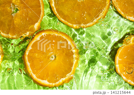 Top view of fresh orange slices submerged in clear rippling water Top view of fresh orange slices submerged in clear rippling water 141215644