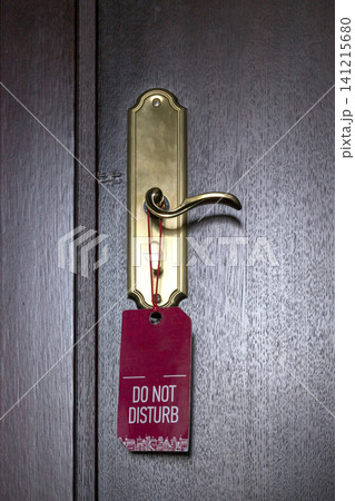 A sign on a hotel doorknob reads "Do not disturb." A sign on a hotel doorknob reads "Do not disturb." 141215680