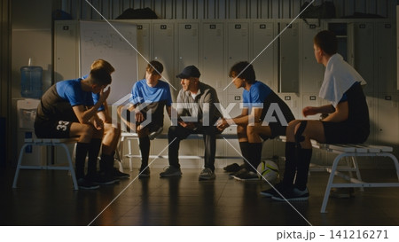 Football Coach Discussing Match Strategy With Youth Team in Locker Room Football Coach Discussing Match Strategy With Youth Team in Locker Room 141216271