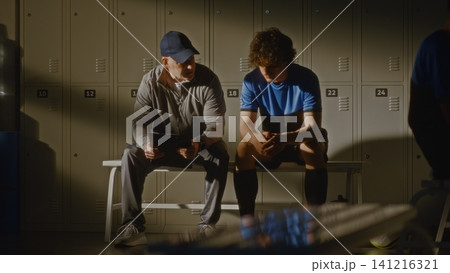 Youth Football Team Locker Room with Coach and Disappointed Player 141216321