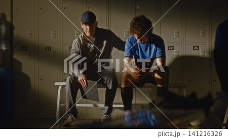 Youth Football Team Locker Room with Coach and Disappointed Player Youth Football Team Locker Room with Coach and Disappointed Player 141216326