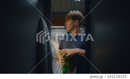 Young Footballer Putting Sports Bag in Locker and Drinking 141216335