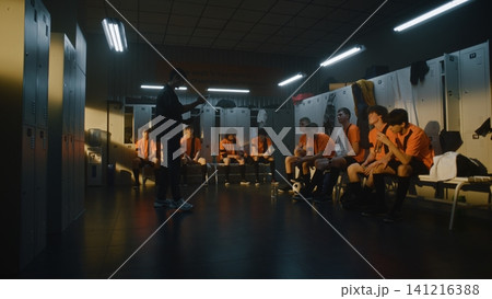Coach Giving Pre Match Instructions to Teenage Football Team in Locker Room 141216388