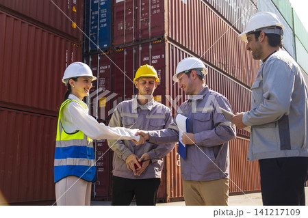 Diverse group of engineers workers discuss problem and workflow in the container yard background. This is a freight transportation and distribution warehouse. Diverse group of engineers workers discuss problem and workflow in the container yard background. This is a freight transportation and distribution warehouse. 141217109
