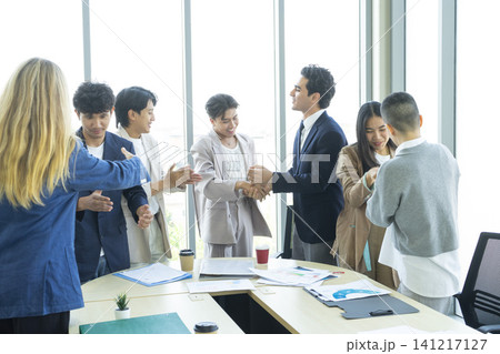 Happy multiracial business team giving high fives gesture, celebrating success. Achievement mission at company. Happy multiracial business team giving high fives gesture, celebrating success. Achievement mission at company. 141217127