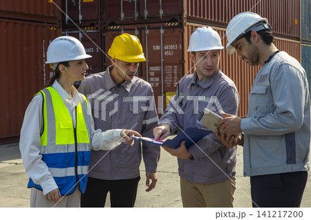Group of engineers working and inspecting freight order in the container yard. This is a freight transportation and distribution warehouse. Group of engineers working and inspecting freight order in the container yard. This is a freight transportation and distribution warehouse. 141217200