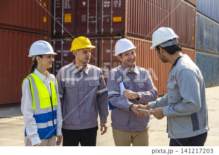 Group of engineers working and inspecting freight order in the container yard. This is a freight transportation and distribution warehouse. 141217203