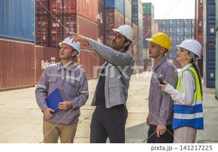 Group of engineers working and inspecting freight order in the container yard. This is a freight transportation and distribution warehouse. 141217225