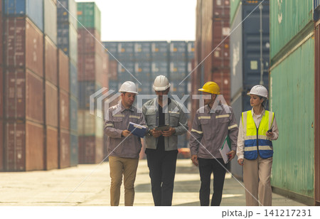 Group of engineers working and inspecting freight order in the container yard. This is a freight transportation and distribution warehouse. Group of engineers working and inspecting freight order in the container yard. This is a freight transportation and distribution warehouse. 141217231