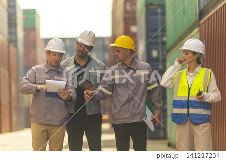 Group of engineers working and inspecting freight order in the container yard. This is a freight transportation and distribution warehouse. Group of engineers working and inspecting freight order in the container yard. This is a freight transportation and distribution warehouse. 141217234