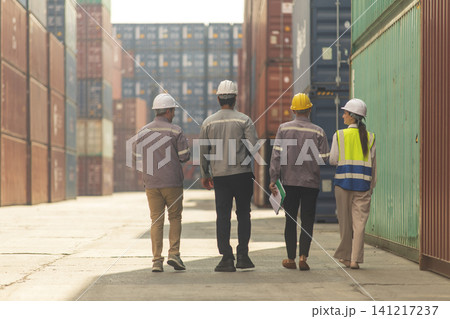 Group of engineers working and inspecting freight order in the container yard. This is a freight transportation and distribution warehouse. Group of engineers working and inspecting freight order in the container yard. This is a freight transportation and distribution warehouse. 141217237