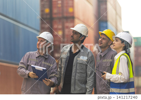 Group of engineers working and inspecting freight order in the container yard. This is a freight transportation and distribution warehouse. Group of engineers working and inspecting freight order in the container yard. This is a freight transportation and distribution warehouse. 141217240