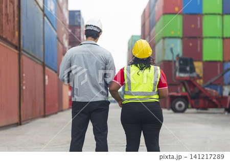 African American female and Latino male worker using tablet, checking workflow loading freight containers from Cargo freight, import export concept. African American female and Latino male worker using tablet, checking workflow loading freight containers from Cargo freight, import export concept. 141217289