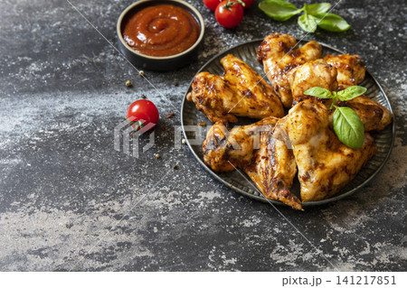 Barbecue chicken wings with sauce on a stone surface. Traditional baked bbq buffalo. Tasty snack for beer. Copy space. 141217851